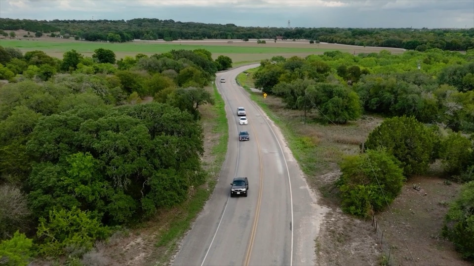 Aerial view of a rural road through Texas brush